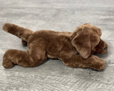 Side view of 22-inch weighted brown dog plush showing long body and floppy legs; up to 7 lb with glass microbeads.