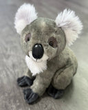 Angled front view of koala plush with large black nose, cute smile,  and soft paws; ultra-soft 12-inch weighted companion.