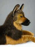 Side profile of lifelike weighted German Shepherd plush showing detailed muzzle, ears, and long black-and-tan coat.