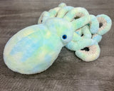 Angled top view highlighting teal, blue and and soft yellow clouds across the octopus head and coiled tentacles.