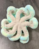 Underside of weighted octopus displaying ribbed beige tentacles and plush construction