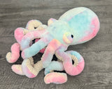 Side view of cotton-candy weighted octopus showing pastel pink, blue and yellow fabric variation and plush curled stretchy tentacles.