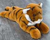 Three-quarter angle of weighted tiger plush showing long body and stripes; up to 5 lbs with glass microbeads.