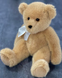 Honey-brown vintage teddy bear with white satin bow sitting upright, 14 inches, ultra-soft weighted plush.