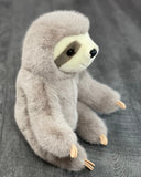 Side angle of weighted sloth plush with open arms and soft claws; ultra-cuddly 16-inch sloth for chest or lap cuddles.
