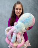 Model holding large pastel blue-pink-yellow cotton-candy weighted octopus with coiled stretchy tentacles.