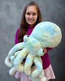 Model holding giant teal green blue weighted octopus to show scale and watercolor fabric variation