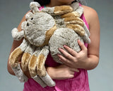 Person cuddling a jumbo weighted tarantula spider plush against their chest, showing size and soft fur.