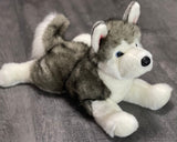 25-inch weighted Husky plush lying down; blue eyes, grey and white fluffy coat, curled tail; up to 11 lbs with glass microbeads.