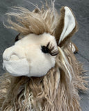 Up close view of weighted llama plush face with shaggy tan fleece and long curly lashes.