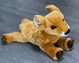 Three-quarter view of the 15" weighted fawn lying flat with spotted back, soft brown eyes, and outstretched legs.
