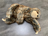 Large weighted sloth plush lying on its side; brown-gray fluffy fur, long arms with cream claws; calming stuffed animal up to 8 lbs.