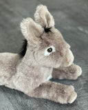 Three-quarter close view of donkey plush with gentle eyes and floppy ears; ultra-soft gray coat for cuddling.
