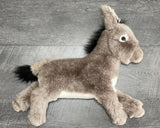 Side angle of weighted donkey plush highlighting low-profile body and plush texture; up to 4 lb with glass microbeads.
