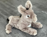 Front three-quarter view of 18-inch weighted donkey; relaxed paws and back legs forward, soft white belly panel.