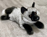 Laying weighted gray fox sensory plush displayed on gray floor—ultra-soft, 4-lb lap companion.