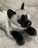 Up close three-quarter view of realistic weighted gray fox plush with dark muzzle and soft fur.