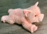 Side profile of weighted pink pig plush showing plush texture and relaxed pose; 17-inch calming companion.