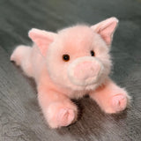 Three-quarter view of 17-inch weighted pink pig plush lying down; ultra-soft fur and sweet face; calming stuffed animal.