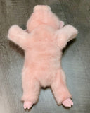 Top-down view of pink pig plush belly and legs outstretched; fluffy fur for cozy lap comfort.