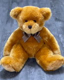 Front view of classic caramel teddy bear (8-12lbs) sitting with floppy limbs and bow, designed for weighted cuddles.