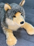 Close-up of wolf plush face with black nose, amber eyes, and creamy muzzle.