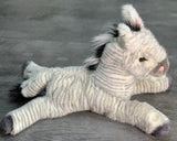 Side profile of 19-inch zebra plush in relaxed laying pose; floppy legs and plush stripes; up to 4 lb with glass microbeads.