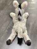 Top/back view of weighted zebra plush showing full length and tail; low-profile 19-inch body for cuddles.