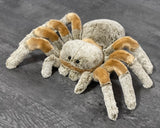 Large tan-and-gray weighted tarantula spider plush with floppy legs on a gray floor, 24-inch leg span.