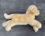 Side view of 19-inch weighted Yellow Labrador retriever plush dog lying down, showing long body, tail, and floppy legs.