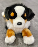 Front close-up of 19-inch weighted Bernese Mountain Dog plush; floppy paws, realistic muzzle and jowls, soft tri-color coat