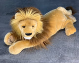 Front/three-quarter view of weighted lion plush in relaxed pose; calm, grounding companion up to 8 lbs.