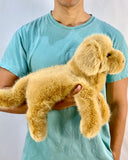 Person holding 19-inch weighted Golden Retriever plush for size reference; lifelike stuffed dog with fluffy coat.