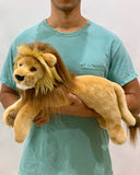 Person holding 22-inch weighted lion plush for size reference; long body and lifelike mane.