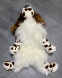 Weighted spaniel dog plush shown flat on back to display soft white belly and spotted paws.