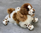 15-inch weighted spaniel plush with brown-and-white spots lying on gray wood surface.