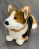 Weighted corgi dog plush looking up, tan/black/white coat on gray surface.