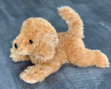 15-inch weighted labradoodle plush with golden-tan curly coat in a play-bow pose on gray wood background