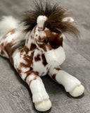 Close-up of weighted appaloosa horse plush face with soft muzzle and tufted mane, ultra-soft with brown and white spotted coat..