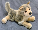 Laying pose of wolf plush with raised tail and forward paws; ultra-soft 15-inch weighted stuffed animal.