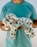 Person holding the spotted pig plush to show scale; soft, floppy 17-inch weighted stuffed animal.