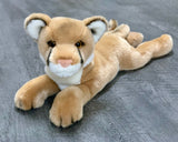 Three-quarter view of 20-inch weighted mountain lion lying down; plush paws forward and relaxed tail.