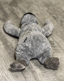 Back view of 22-inch weighted penguin plush showing low-profile body and webbed feet.