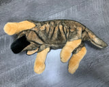 Side-lying weighted German Shepherd plush lying on its back showing underside with black-and-tan coat and tan paws on gray floor