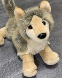 Front three-quarter view of wolf plush lying down with sweet face and plush paws; 15-inch weighted companion.