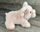 Side view of weighted pink pig stuffed animal with soft pink plush and floppy body