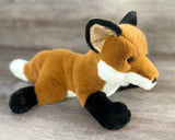 Side angle of weighted fox plush lying down with floppy body and super-soft plush fur