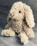 Weighted curly bunny plush sitting with floppy ears and soft cream-colored curly fur.