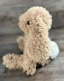 Side view of weighted curly bunny stuffed animal with long floppy ears and curly plush fur, and fluffy white tail.
