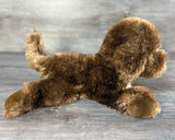 Side view of Chocolate Labradoodle weighted stuffed dog with laying floppy body and raised tail